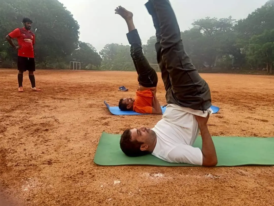 Clients practising shoulder stand outdoors