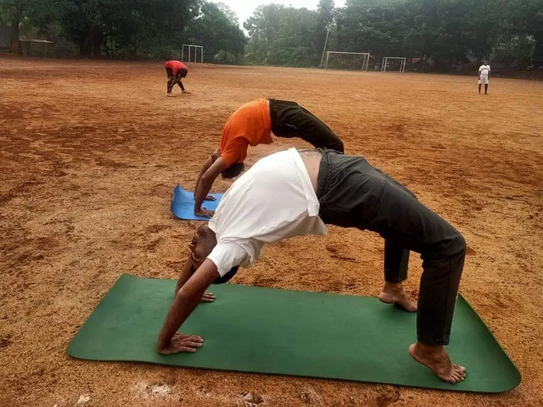 Clients performing wheel pose outdoors